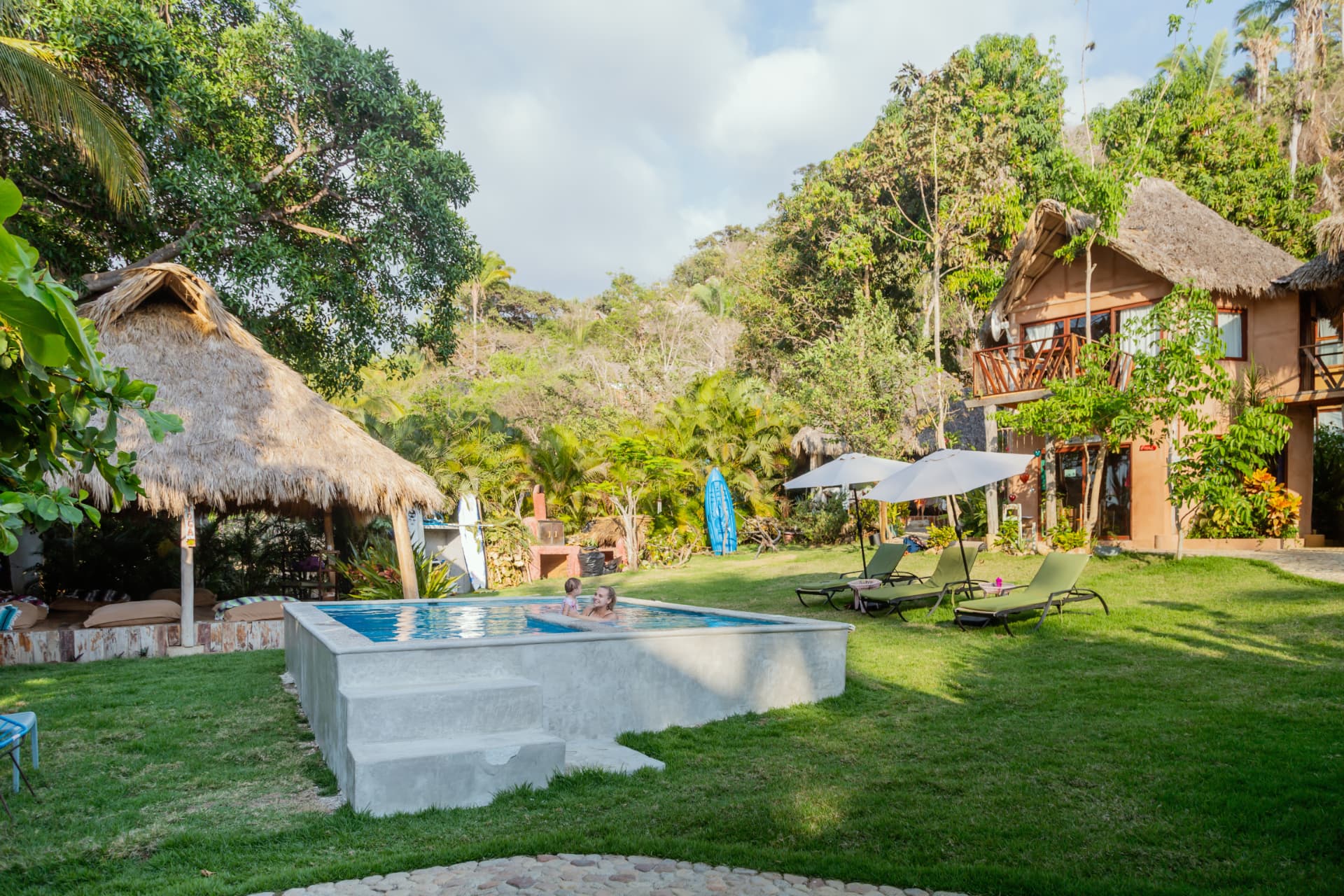 Garden pool with loungers and jungle views