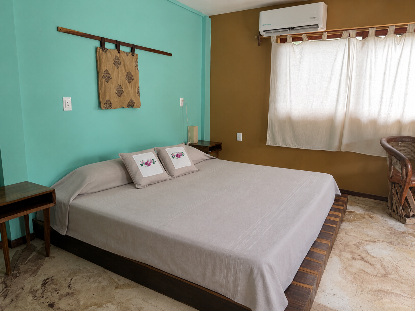 Viento: cama King con muro turquesa y textiles bordados
