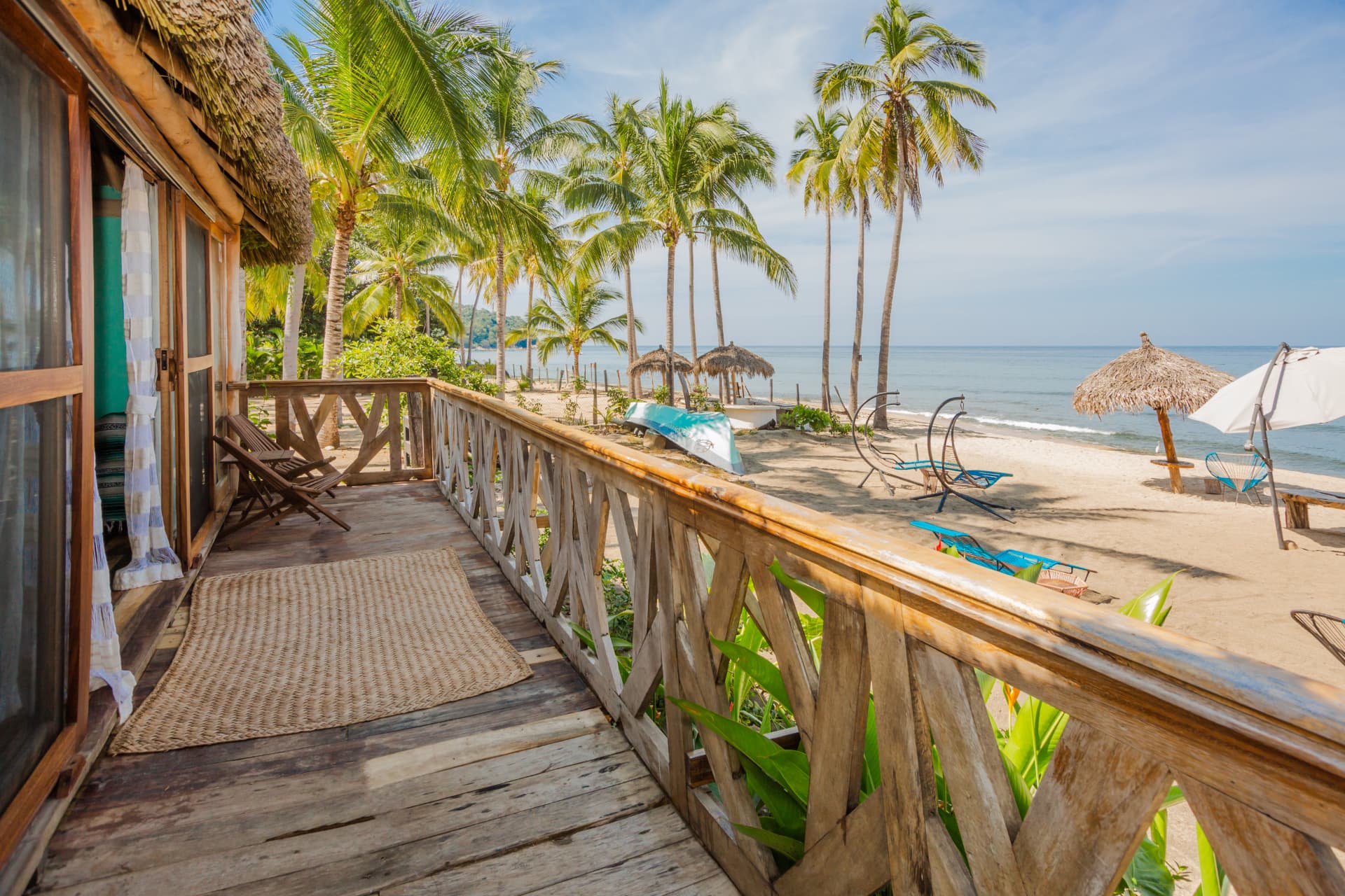 Terraza de la Beachfront Master Suite con vista al mar y palmeras