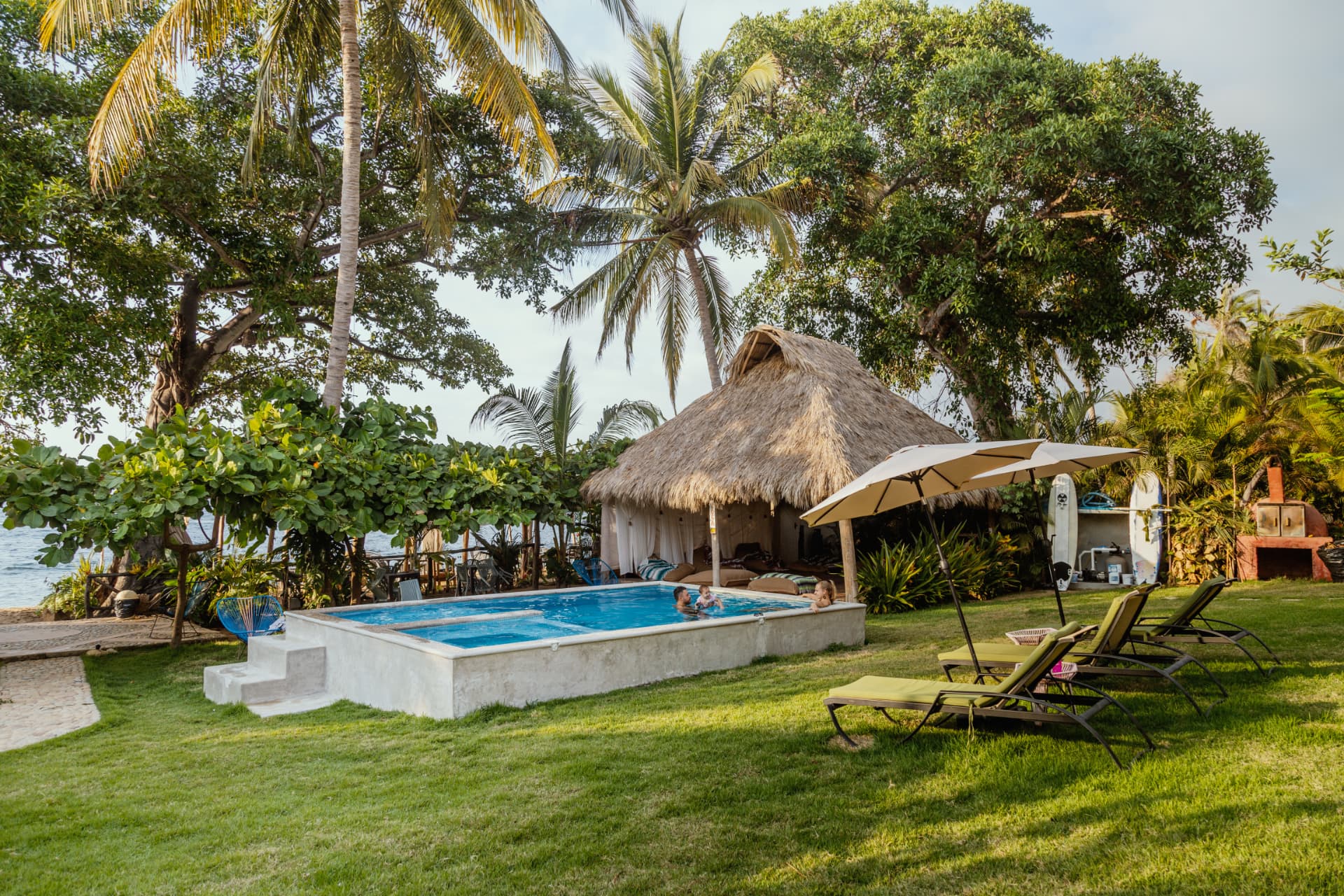 Pool next to the beach club palapa at golden hour