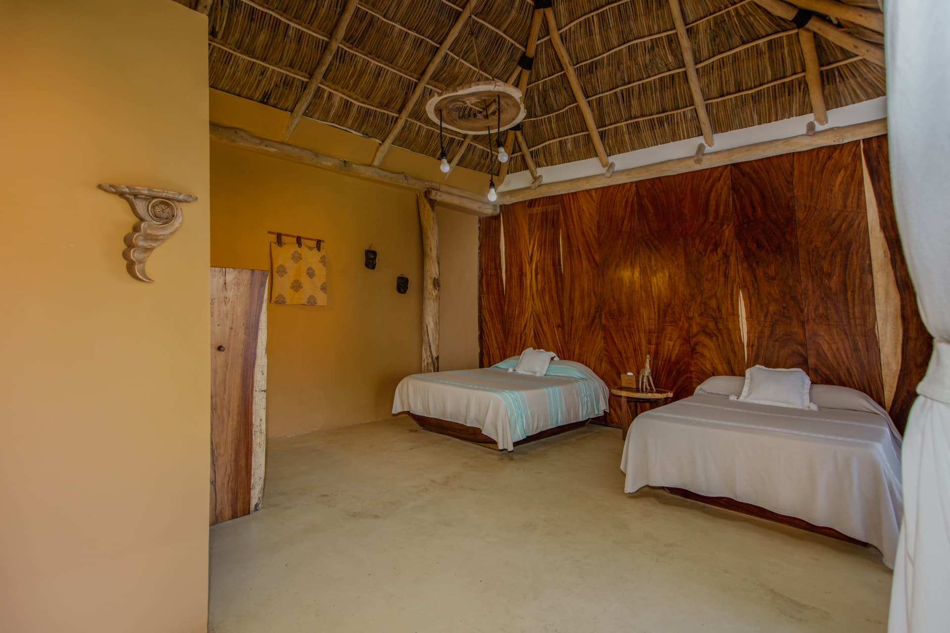 Sol: dos camas Queen bajo techo de palapa con muro de parota