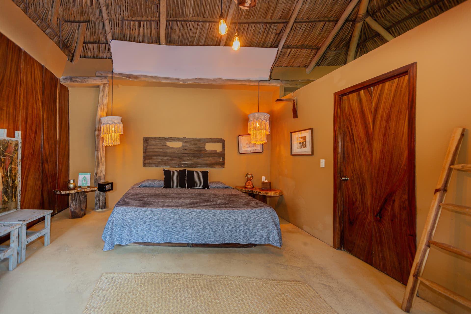 Luna: cama King bajo techo de palapa con lámparas de macramé