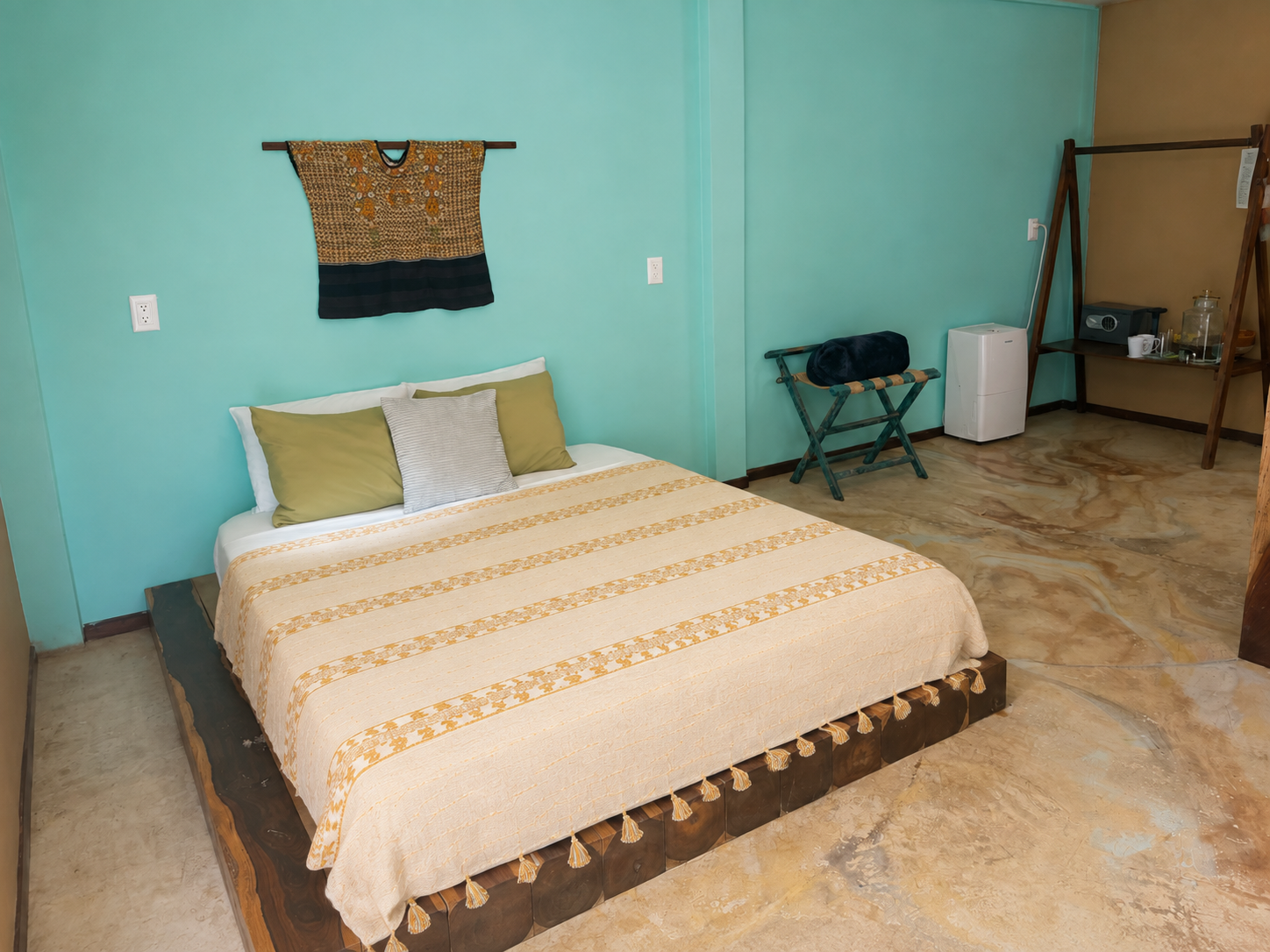 Habitación Estándar Room Queen Size con cama de madera, textiles artesanales y piso de microcemento