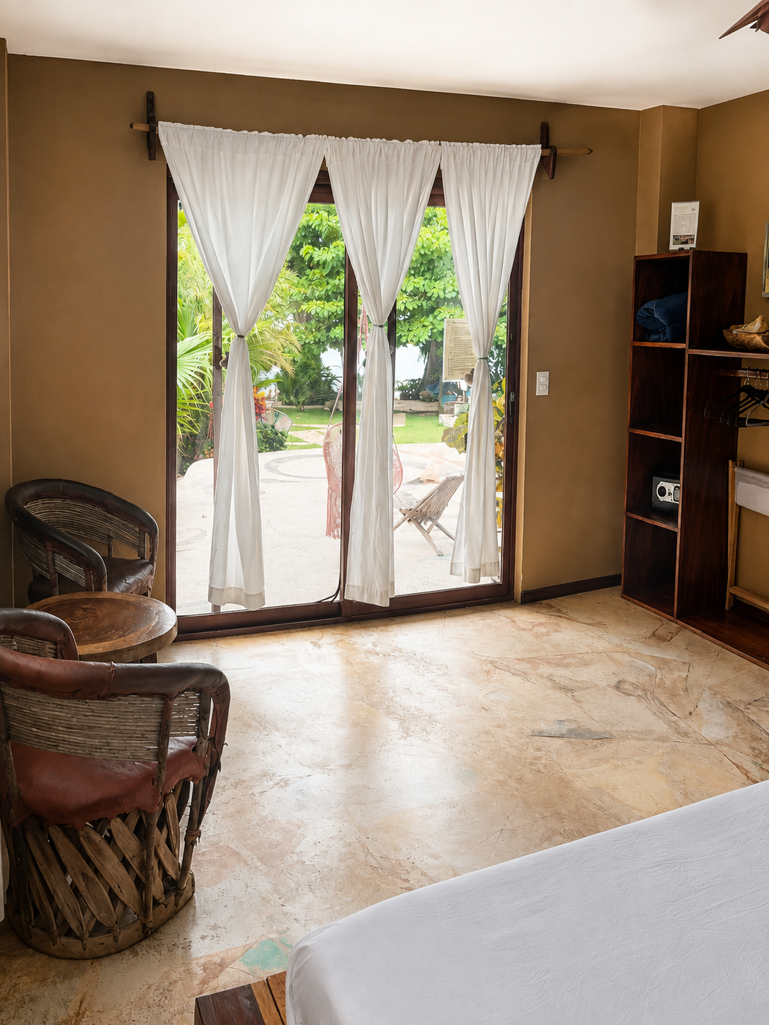 Interior de la Suite King Size Room con puertas abiertas al jardín y al mar