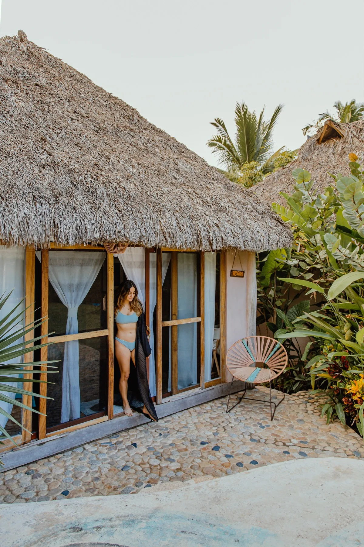 Palm-roof room surrounded by tropical greenery